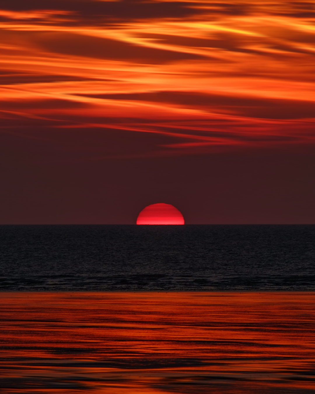 Sunrise on the horizon line above the sea with orange skies